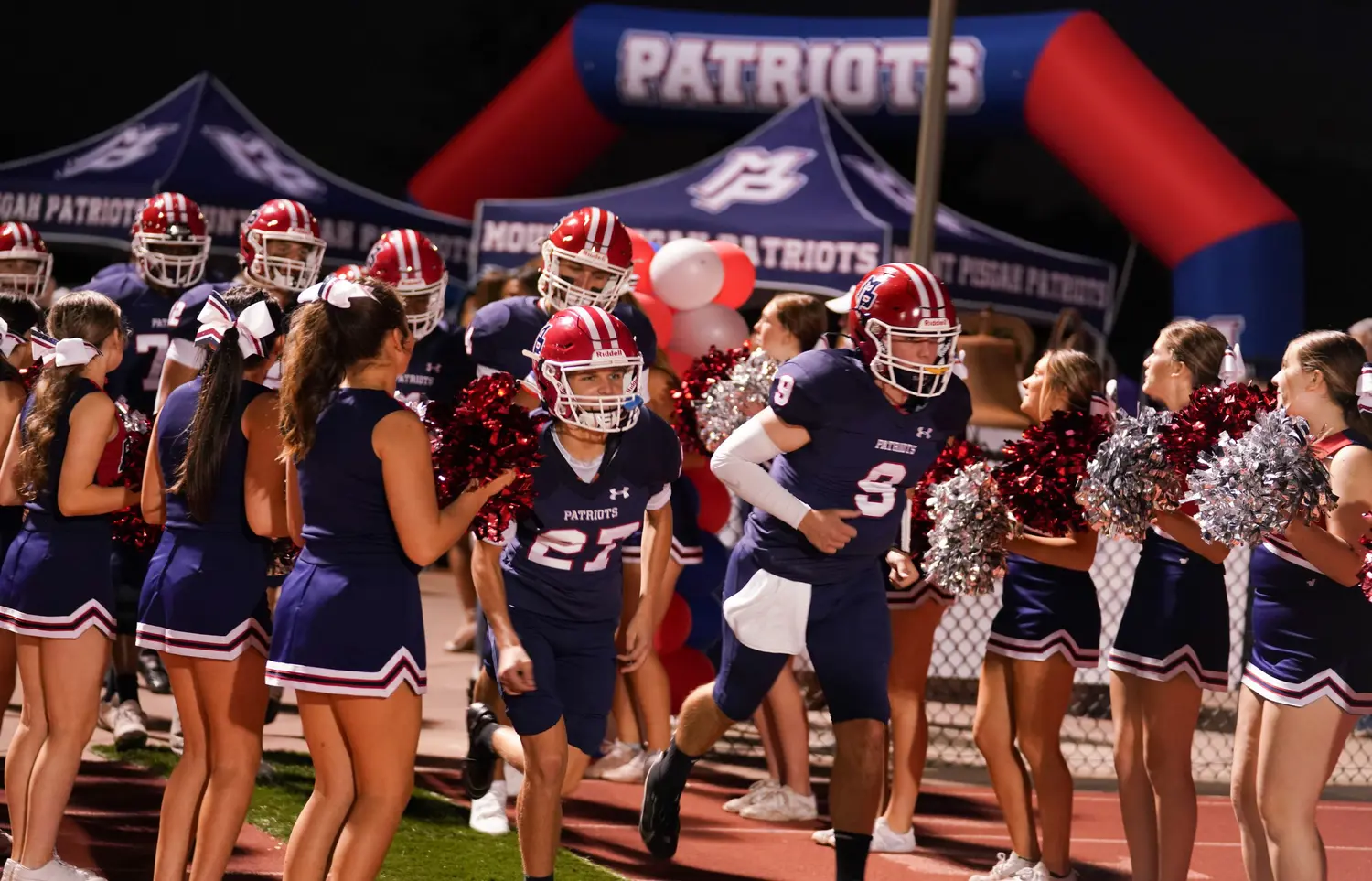 Cheerleaders welcoming athletes to the field